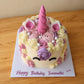 High-angle view of a fondant unicorn cake decorated with pink and cream piped flowers