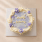 Top view of a lilac vintage birthday cake with personalised Happy Birthday writing