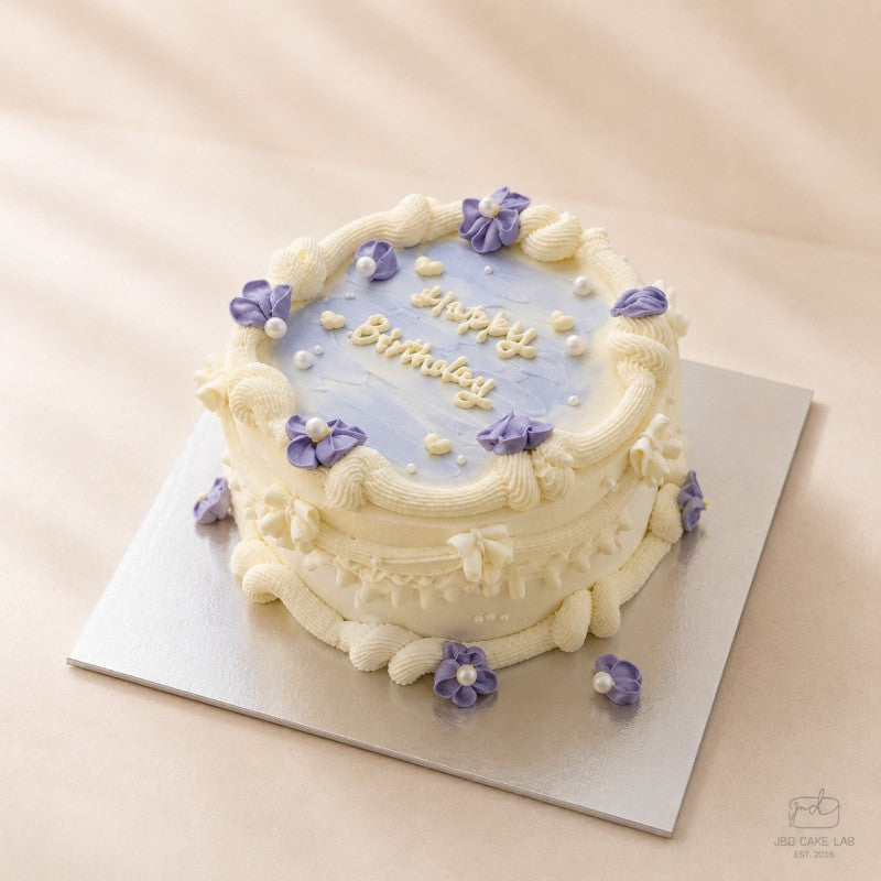 Lilac vintage birthday cake with purple flowers and cream piping in Adelaide