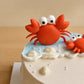 Close-up of handmade orange fondant crab decoration on an ocean-themed birthday cake