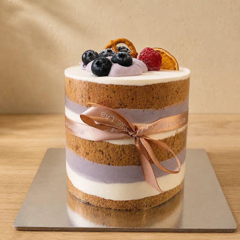 Close-up of Taro Naked Cake showing exposed chiffon and taro cream layers through the clear cake collar