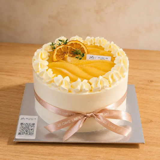 Front view of Lemon Yuzu Cream Cake with smooth cream finish, citrus topping and ribbon detail