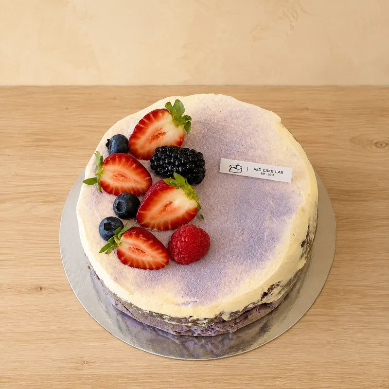 Top view of taro and ube Basque burnt cheesecake with strawberries, berries and cream in Adelaide