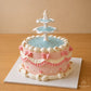 High-angle view of a Wishing Fountain vintage cake with a blue water-effect centre and angel topper