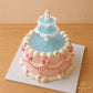 Front view of a Wishing Fountain vintage cake with ruffled piping, bows and gold star details