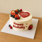 Three-quarter view of seasonal fruit celebration cake with custom heart message plaque