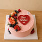 Top view of pink personalised heart message cake decorated with strawberries and mixed berries