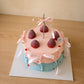 High-angle view of pastel Ribbon and Ruffles Cake topped with strawberries and ribbon details