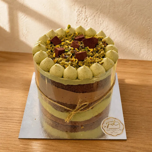 Front view of Dubai chocolate pistachio cake showing chocolate sponge and contrasting cream layers