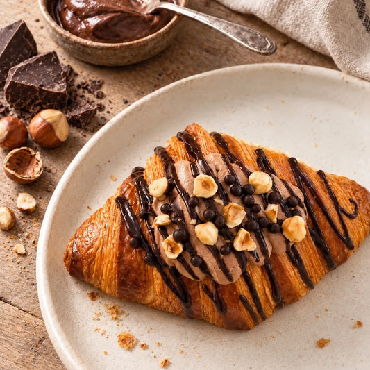 Double Choc Hazelnut Lava Croissant topped with chocolate cream, roasted hazelnuts and a drizzle of chocolate ganache.