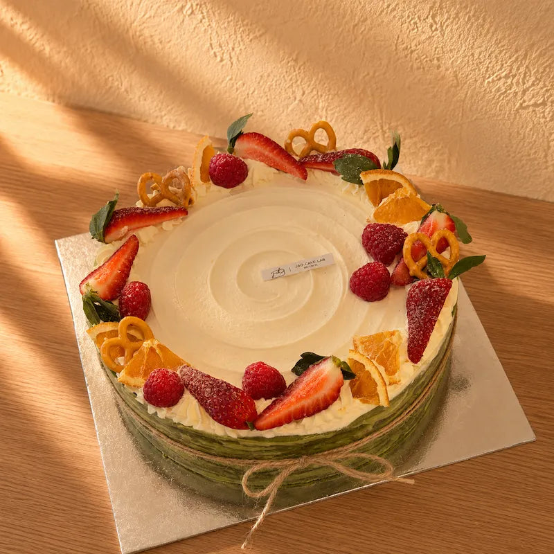Front view of matcha mille crepe cake showing green crepe layers and a twine bow
